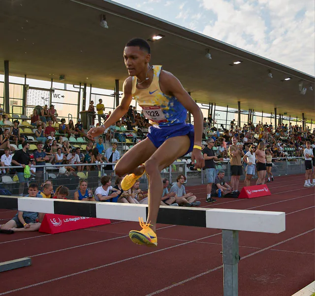 Noah Cais clearing a steeplechase barrier during a race